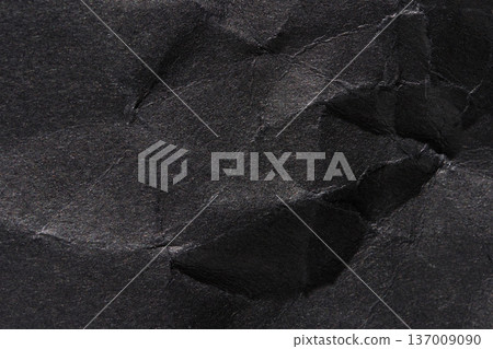 Close-up of crumpled black paper texture with detailed creases and wrinkles Close-up of crumpled black paper texture with detailed creases and wrinkles 137009090