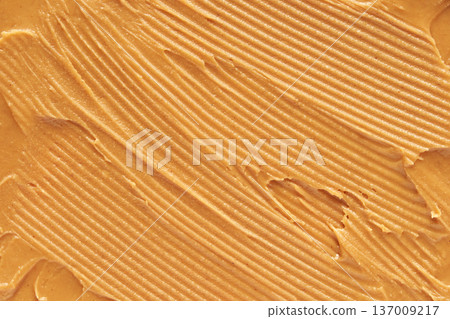 Creamy Smooth Peanut Butter Spread Texture With Rich Golden Brown Color And Even, Wavy Patterns 137009217