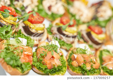 Assorted bruschetta with fresh vegetables, herbs, and salmon on a platter Assorted bruschetta with fresh vegetables, herbs, and salmon on a platter 137009257