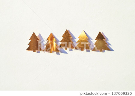 Golden Metallic Christmas Tree Cutouts On White Background For Festive Decoration And Holiday Golden Metallic Christmas Tree Cutouts On White Background For Festive Decoration And Holiday 137009320
