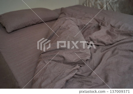 Crumpled brown bed sheets and pillow on unmade bed in cozy bedroom setting Crumpled brown bed sheets and pillow on unmade bed in cozy bedroom setting 137009371