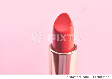 Red lipstick on pink background close-up of cosmetic tube highlighting beauty and glamour 137009543