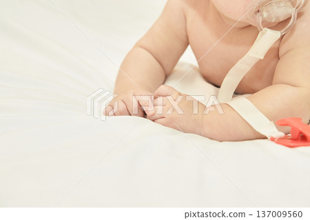 Close-Up Of Caucasian Baby With Pacifier On Soft White Bed Linen In Peaceful Setting 137009560