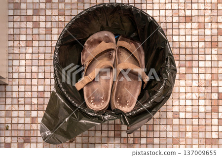 Worn out sandals thrown in garbage 137009655