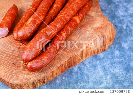Chorizo sausages are arranged on wooden board in kitchen setting food preparation for serving Chorizo sausages are arranged on wooden board in kitchen setting food preparation for serving 137009758