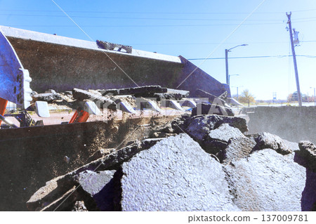 Tractor machine is breaking asphalt on road during road works Tractor machine is breaking asphalt on road during road works 137009781