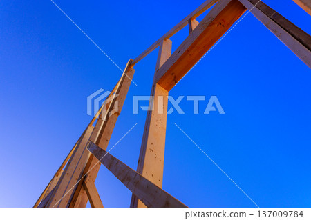 Timber framework beams stands tall against construction progress design. 137009784