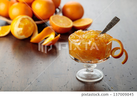 Orange jam in a glass dessert bowl on an old wooden table. Orange jam in a glass dessert bowl on an old wooden table. 137009845