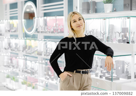 Saleswoman smiling and posing in jewelry shop Saleswoman smiling and posing in jewelry shop 137009882