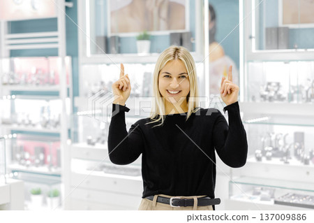 Saleswoman pointing up in jewelry store Saleswoman pointing up in jewelry store 137009886