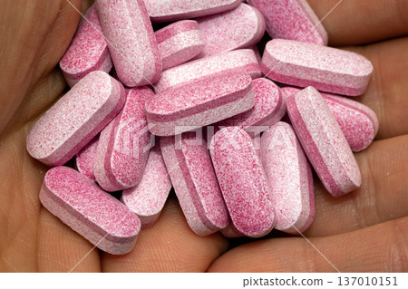 Holding pink pills in hand 137010151
