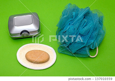 Soap next to plastic box and body scrub Soap next to plastic box and body scrub 137010359