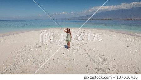 Beautiful woman relax on pristine white sandbar, turquoise water on tranquil Gili Islands sand beach, soaking up sunshine and a peaceful tropical escape. Summer vacation on Lombok. Aerial view 137010416