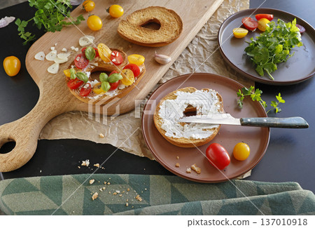 Round bruschetta with red and yellow cherry tomatoes and goat cheese on oak wooden board. Farm produce, crusty bread. Food and healthy eating. Round bruschetta with red and yellow cherry tomatoes and goat cheese on oak wooden board. Farm produce, crusty bread. Food and healthy eating. 137010918