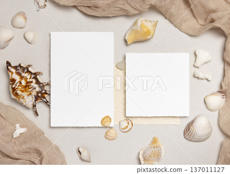 Mockup of blank cards on beige stone with seashells, top view. Coastal wedding stationery Mockup of blank cards on beige stone with seashells, top view. Coastal wedding stationery 137011127