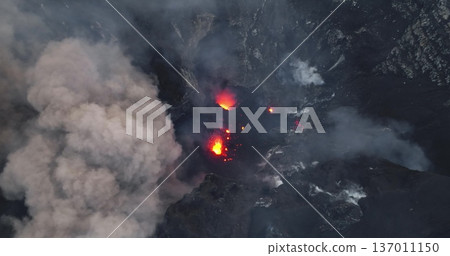 Vanuatu, Tana island, Yasur Volcano active crater erupting incandescent lava, hot ash, dense smoke plumes, raw power of nature and geological activity. Natural phenomena. Aerial drone flight footage Vanuatu, Tana island, Yasur Volcano active crater erupting incandescent lava, hot ash, dense smoke plumes, raw power of nature and geological activity. Natural phenomena. Aerial drone flight footage 137011150