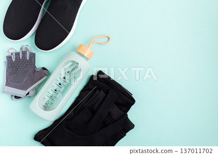 Fitness apparel and accessories laid out on a blue background. 137011702