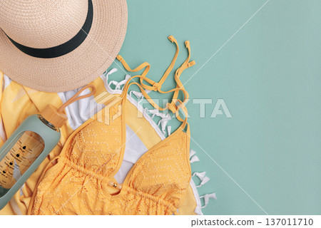 Beach essentials including swimwear, hat, towel, and water bottle. Beach essentials including swimwear, hat, towel, and water bottle. 137011710