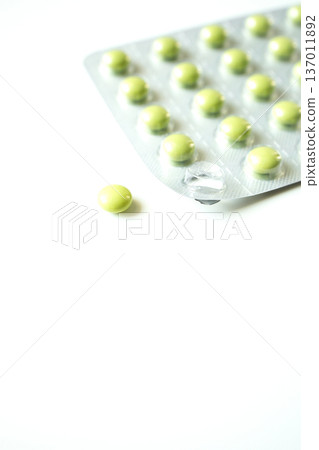 Green pills in a blister pack on white background. Healthcare and medicine, pharmaceutical industry. 137011892
