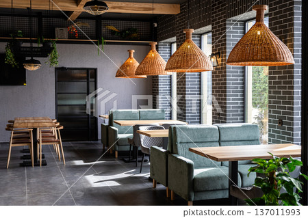 Modern cafe interior with cozy booths and rattan pendant lights in daylight Modern cafe interior with cozy booths and rattan pendant lights in daylight 137011993