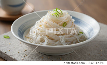蒟蒻麵配上蔥花和芝麻，精美地擺放在日式餐具上，置於淺色木桌上。 137012490