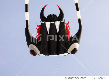 A colorful kite flies high above a park. Freedom and playful outdoor joy. 137012690