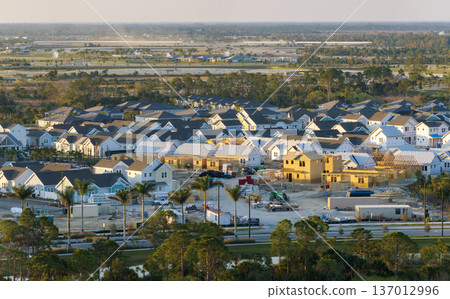 Aerial view of unfinished wooden frames of affordable houses under construction. Development of residential housing in American suburbs. Real estate market in the USA 137012996