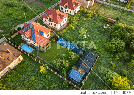 Aerial view of rural residential area with private homes between green fields at sunrise. Aerial view of rural residential area with private homes between green fields at sunrise. 137013079