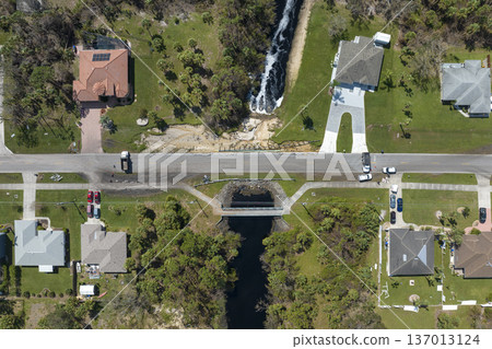 Road construction. Trucks blocking car access at destroyed bridge after hurricane flooding water washed away asphalt in Florida. Safety equipment at roadwork site Road construction. Trucks blocking car access at destroyed bridge after hurricane flooding water washed away asphalt in Florida. Safety equipment at roadwork site 137013124