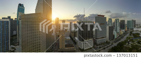 Aerial view of downtown district of of Miami Brickell in Florida, USA at sunset. High skyscraper buildings and street with cars and Metrorail traffic in modern american midtown Aerial view of downtown district of of Miami Brickell in Florida, USA at sunset. High skyscraper buildings and street with cars and Metrorail traffic in modern american midtown 137013151