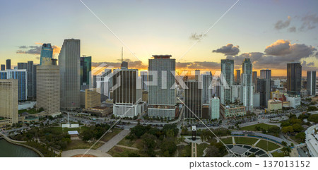 Evening urban landscape of downtown district of Miami Brickell in Florida USA. Skyline with dark high skyscraper buildings and street with cars and Metrorail traffic in modern american megapolis 137013152