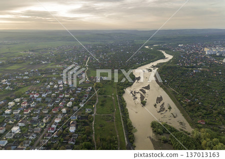 Aerial view of Ivano-Frankivsk city with residential area and suburb houses with a river in middle. 137013163