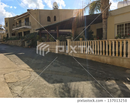Residential street with Mediterranean houses and palm tree. Suburban lifestyle, architecture and sunny climate concept Residential street with Mediterranean houses and palm tree. Suburban lifestyle, architecture and sunny climate concept 137013258