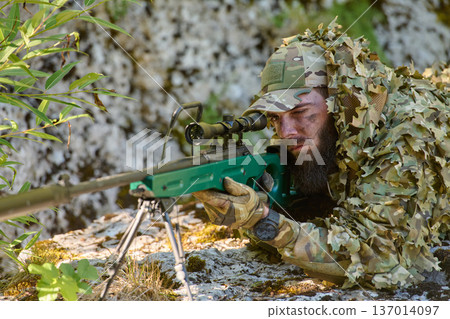 Camouflaged Sniper Soldier In Ghillie Suit Aiming Precision Rifle From Concealed Position Camouflaged Sniper Soldier In Ghillie Suit Aiming Precision Rifle From Concealed Position 137014097
