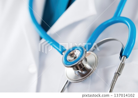 Closeup view of a Stethoscope placed carefully on a Doctors crisp White Coat garment Closeup view of a Stethoscope placed carefully on a Doctors crisp White Coat garment 137014102