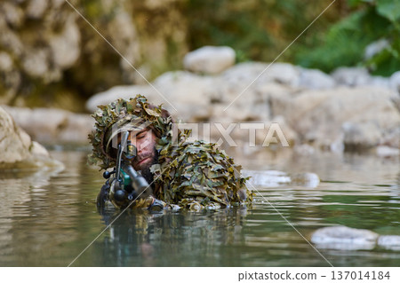 Sniper In Ghillie Suit Wading Through Water With Rifle, Camouflage Soldier Conducting Reconnaissance 137014184