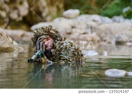 Camouflaged Sniper in Ghillie Suit Wading Through Water Aiming Rifle During Military Training Camouflaged Sniper in Ghillie Suit Wading Through Water Aiming Rifle During Military Training 137014197