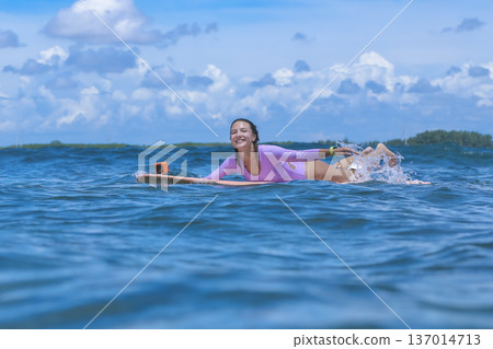 Relaxed Young Lady Enjoying Peaceful Surf Session Under Cloudy Sky 137014713
