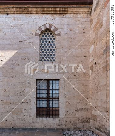 Mevlana Museum stone wall with arched window featuring circular panes and a barred window, Konya Turkey Mevlana Museum stone wall with arched window featuring circular panes and a barred window, Konya Turkey 137015095