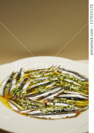 [Vertical] Pickled anchovies on a plate, a traditional Spanish tapas 137015178