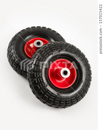 Two wheels from a garden cart on a white background. Black rubber, red disc. Two wheels from a garden cart on a white background. Black rubber, red disc. 137015422