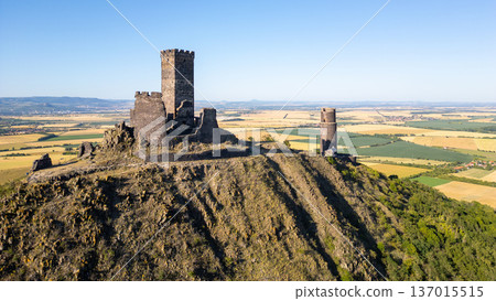 Hazmburk castle ruins stand proudly atop a hill, offering breathtaking views of the Central Bohemian Uplands. This medieval fortress showcases rich history amid the serene landscape of Czechia. Hazmburk castle ruins stand proudly atop a hill, offering breathtaking views of the Central Bohemian Uplands. This medieval fortress showcases rich history amid the serene landscape of Czechia. 137015515