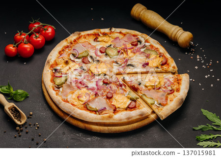 Fresh baked pizza with ham sausage cheese and vegetables on dark rustic background Fresh baked pizza with ham sausage cheese and vegetables on dark rustic background 137015981