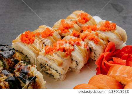 Sushi rolls with eel sauce and tobiko served on white plate closeup Japanese cuisine Sushi rolls with eel sauce and tobiko served on white plate closeup Japanese cuisine 137015988