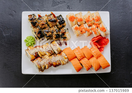 Assorted sushi rolls with salmon eel and tobiko served on white plate top view Assorted sushi rolls with salmon eel and tobiko served on white plate top view 137015989