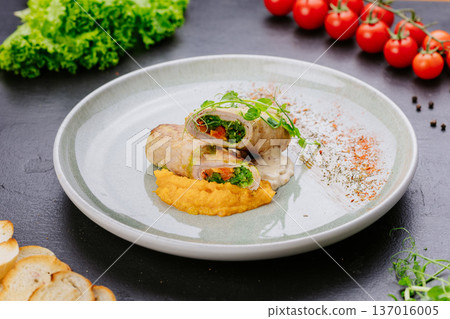 Stuffed chicken roll with vegetable filling and puree served on restaurant plate Stuffed chicken roll with vegetable filling and puree served on restaurant plate 137016005