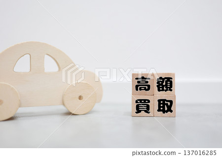 木製玩具和字母積木展示了高昂的汽車購買價格。 木製玩具和字母積木展示了高昂的汽車購買價格。 137016285