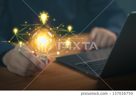 Glowing light bulb in a hand with connected idea network graphics, symbolizing creativity, innovation, brainstorming, technology, inspiration, smart thinking, and modern digital problem-solving. Glowing light bulb in a hand with connected idea network graphics, symbolizing creativity, innovation, brainstorming, technology, inspiration, smart thinking, and modern digital problem-solving. 137016750