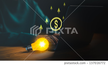 A glowing lightbulb beside a laptop symbolizes creativity, innovation, and online income growth, with digital dollar icons and upward arrows representing business ideas, and financial success. 137016772