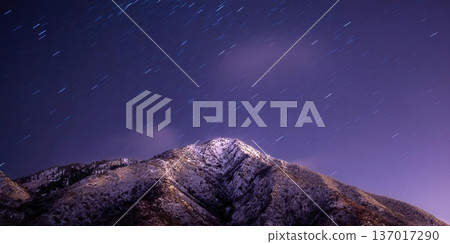 Night Sky Star Trails Above Snow-Capped Mountain 137017290